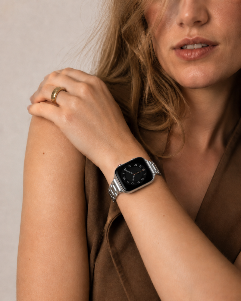 Woman wearing silver steel strap smartwatch with matching gold ring
