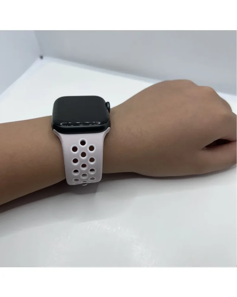 White perforated sport band for smartwatch with black case displayed on wrist